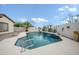 Inviting pool with tile waterfall feature, surrounding desert plants, and stone wall in backyard at 11122 N 165Th Ave, Surprise, AZ 85388