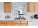 Kitchen sink and countertop area with stainless steel sink, wood cabinets, and view of the living room at 11616 N Saguaro Blvd # 2, Fountain Hills, AZ 85268