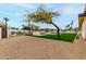 Landscaped backyard with drought-tolerant gravel, artificial turf, and a mature tree at 12240 N 62Nd Pl, Scottsdale, AZ 85254