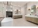 A luxurious bathroom featuring a double vanity, a soaking tub, and sleek contemporary finishes at 12240 N 62Nd Pl, Scottsdale, AZ 85254