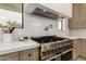 Close up of the kitchen with stainless steel range, hood, quartz countertop and backsplash at 12240 N 62Nd Pl, Scottsdale, AZ 85254