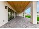 Covered outdoor patio area features a herringbone tile pattern floor and a wood ceiling at 12240 N 62Nd Pl, Scottsdale, AZ 85254