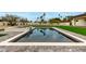 Modern pool with stone surround reflecting trees and sky provides a luxurious backyard oasis at 12240 N 62Nd Pl, Scottsdale, AZ 85254