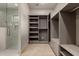 This ample walk-in closet has custom shelving with a bright, light grey color scheme and hardwood floors at 12240 N 62Nd Pl, Scottsdale, AZ 85254