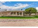 Bright backyard featuring a well-manicured lawn and a mature fruit tree next to a home with large picture windows at 12810 W Ashwood Dr, Sun City West, AZ 85375