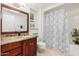 Well-lit bathroom featuring a granite-topped vanity and shower-tub combo at 12810 W Ashwood Dr, Sun City West, AZ 85375