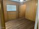 Bedroom with wood paneling, wood-look flooring, and a window with blinds at 13229 N 19Th Pl, Phoenix, AZ 85022