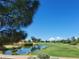 Scenic golf course view with a tranquil pond and mature landscaping offering a serene escape at 14314 W Pecos Ln, Sun City West, AZ 85375