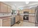 Traditional style kitchen with stainless steel appliances, light cabinetry, and tile floors at 14314 W Pecos Ln, Sun City West, AZ 85375