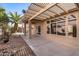 Covered patio features shade structure, desert landscaping, and a sliding glass door at 14314 W Pecos Ln, Sun City West, AZ 85375