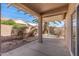 Covered patio with a shade structure, desert landscaping, and a view of a palm tree at 14314 W Pecos Ln, Sun City West, AZ 85375