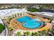 Aerial view of a large outdoor pool with palm trees, lounge chairs, and a recreational area at 14314 W Pecos Ln, Sun City West, AZ 85375