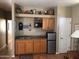 Wet bar featuring wood cabinets, sink, microwave, mini refrigerator, shelving and decor at 14925 E Morning Vista Ln, Scottsdale, AZ 85262