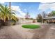 Expansive backyard with gravel, artificial turf, hammock, palm tree, and covered patio area at 1512 W Fairmont Dr, Tempe, AZ 85282