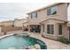 Spacious backyard with a covered patio, outdoor kitchen, and an inviting swimming pool with a rock waterfall at 15658 W Cortez St, Surprise, AZ 85379