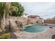 Inviting backyard with a refreshing pool, rock waterfall feature, and privacy wall with bougainvillea at 15658 W Cortez St, Surprise, AZ 85379