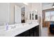 Bright bathroom featuring double sink vanity with sleek countertops and a large mirror at 15658 W Cortez St, Surprise, AZ 85379