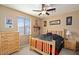 Cozy bedroom with natural light, a ceiling fan, wooden furniture, and neutral-colored walls at 15658 W Cortez St, Surprise, AZ 85379