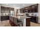 Modern kitchen featuring dark cabinetry, a large granite island, and stainless steel appliances at 15658 W Cortez St, Surprise, AZ 85379