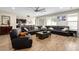 Comfortable living room featuring a large leather sectional, wood-look flooring, and plenty of natural light at 15658 W Cortez St, Surprise, AZ 85379