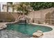 Inviting swimming pool with a rock waterfall feature and lush landscaping in the private backyard at 15658 W Cortez St, Surprise, AZ 85379