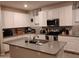 Modern kitchen boasting white cabinets, stainless steel appliances, island with sink, and mosaic tile backsplash at 16648 W Jenan Dr, Surprise, AZ 85388