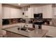 Spacious kitchen featuring white cabinets, stainless steel appliances, and a gray island countertop at 16648 W Jenan Dr, Surprise, AZ 85388