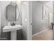 Elegant half-bathroom with pedestal sink, decorative mirror, and neutral wall color at 1735 W Wildwood Dr, Phoenix, AZ 85045