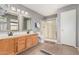 Bathroom with double sink vanity, decorative mirrors, and glass shower stall at 1735 W Wildwood Dr, Phoenix, AZ 85045