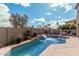 Backyard view showcasing a refreshing in-ground pool with a waterfall feature and ample seating at 1735 W Wildwood Dr, Phoenix, AZ 85045