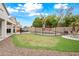 Expansive backyard featuring a putting green, covered patio, and fenced pool at 17771 W Caribbean Ln, Surprise, AZ 85388