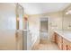 Primary bathroom featuring dual sinks, a soaking tub, glass-enclosed shower, and large windows at 17771 W Caribbean Ln, Surprise, AZ 85388