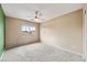 Empty bedroom with white ceiling fan and neutral paint, showcasing a bright, airy space at 17771 W Caribbean Ln, Surprise, AZ 85388