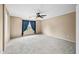 Spacious bedroom featuring a ceiling fan and a window with blue curtains for natural light at 17771 W Caribbean Ln, Surprise, AZ 85388