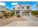 Inviting two-story house featuring neutral tones, a covered entrance, and well-maintained landscaping at 17771 W Caribbean Ln, Surprise, AZ 85388