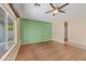 Open-concept living room with hardwood floors, a ceiling fan, and a green accent wall at 17771 W Caribbean Ln, Surprise, AZ 85388