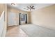 Bright, carpeted living room features a ceiling fan and a large window at 17771 W Caribbean Ln, Surprise, AZ 85388