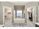 Bright bathroom featuring a soaking tub between two walk-in closets at 18097 W Santa Alberta Ln, Goodyear, AZ 85338