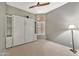 Bedroom featuring a Murphy bed, ceiling fan, neutral walls, and window at 18097 W Santa Alberta Ln, Goodyear, AZ 85338