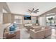 Bright and airy living room with modern furniture, wood floors, and a view to the backyard patio at 18097 W Santa Alberta Ln, Goodyear, AZ 85338