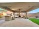 Outdoor kitchen featuring a ceiling fan, string lights, a built-in grill, and outdoor fireplace at 18097 W Santa Alberta Ln, Goodyear, AZ 85338