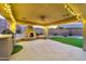 Outdoor kitchen with string lights, built in BBQ and fireplace and beautiful patio at 18097 W Santa Alberta Ln, Goodyear, AZ 85338