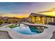 Relaxing backyard featuring a sparkling pool, a covered outdoor dining area, and manicured landscaping at sunset at 18097 W Santa Alberta Ln, Goodyear, AZ 85338