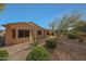 Landscaped backyard featuring a covered patio and desert landscaping with cacti, shrubs, and rocks at 18670 N Rincon Ct, Surprise, AZ 85387