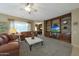 Inviting living room area with a large built-in bookcase, comfortable seating, and natural lighting at 18670 N Rincon Ct, Surprise, AZ 85387