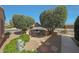 Charming outdoor patio with a table, chairs, landscaping, and shade trees at 18670 N Rincon Ct, Surprise, AZ 85387