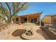 Covered patio featuring a cozy sitting area and a modern fire pit with stone surround at 18670 N Rincon Ct, Surprise, AZ 85387