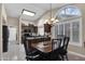 Open kitchen and dining area with a chandelier, arched windows, and tile flooring at 18730 N 89Th Ave, Peoria, AZ 85382