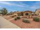 Charming single-story home with desert landscaping, a paved driveway, and a stone accent wall at 18730 N 89Th Ave, Peoria, AZ 85382