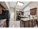 Bright kitchen featuring dark cabinets, granite countertops, stainless steel appliances, and a skylight at 18730 N 89Th Ave, Peoria, AZ 85382